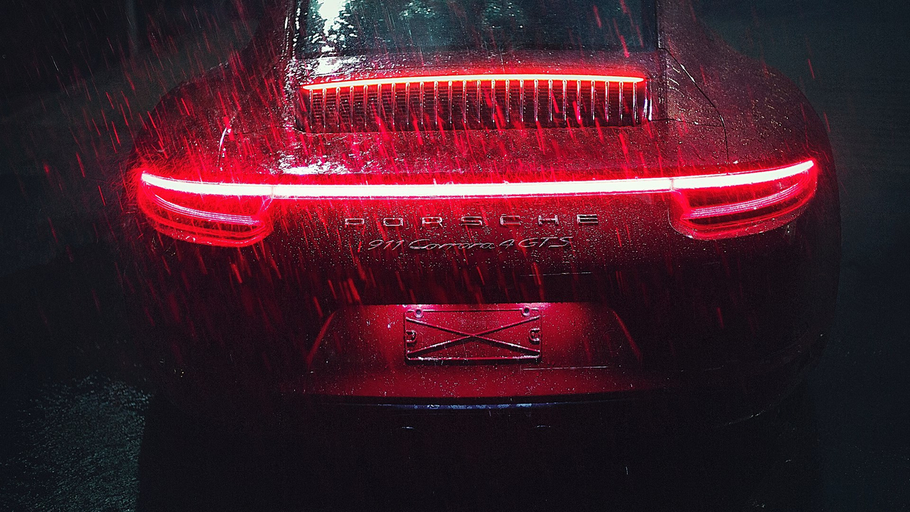 Porsche 911 Carrera Outdoor LED Red Lights Rain Автомобиль Porsche 911 Carrera вид сзади стоит под дождем, горят задние огни