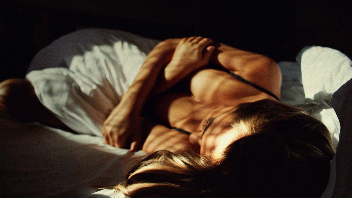 Woman Brunette Bed Sunset Lights Красивая девушка брюнетка лежит на постели в окно светят лучи солнца на закате