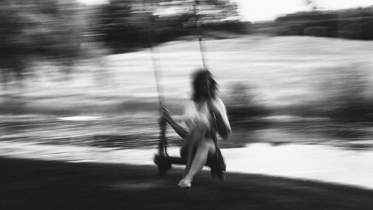 Woman Back Wind Swing Девушка с короткой стрижкой катается на качелях в черно белом фото летит с сторону