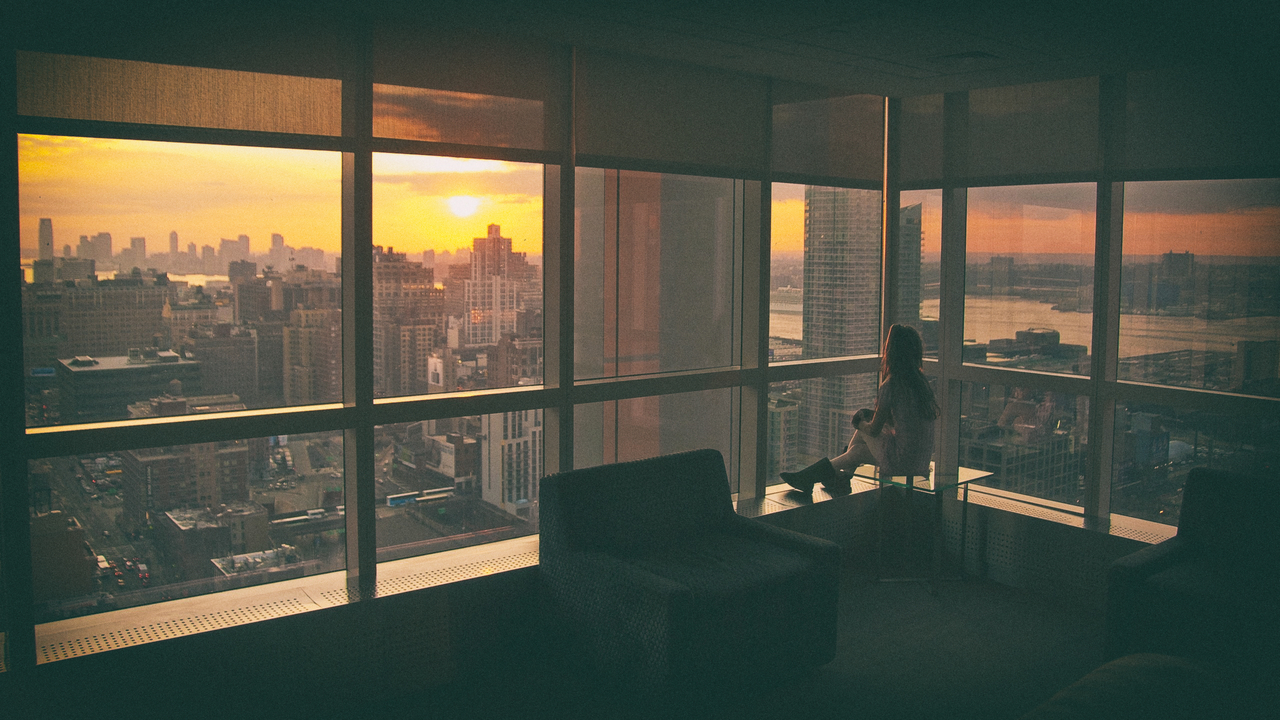 Urban City Penthouses Woman Sit Big Window Home девушка сидит на столе и смотрит в большое окно небоскреба на фоне заката
