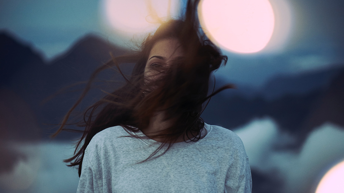 Woman Brunette Hair Wind Landscape Blur Девушка брюнетка стоит на фоне гор дует ветер в волосы