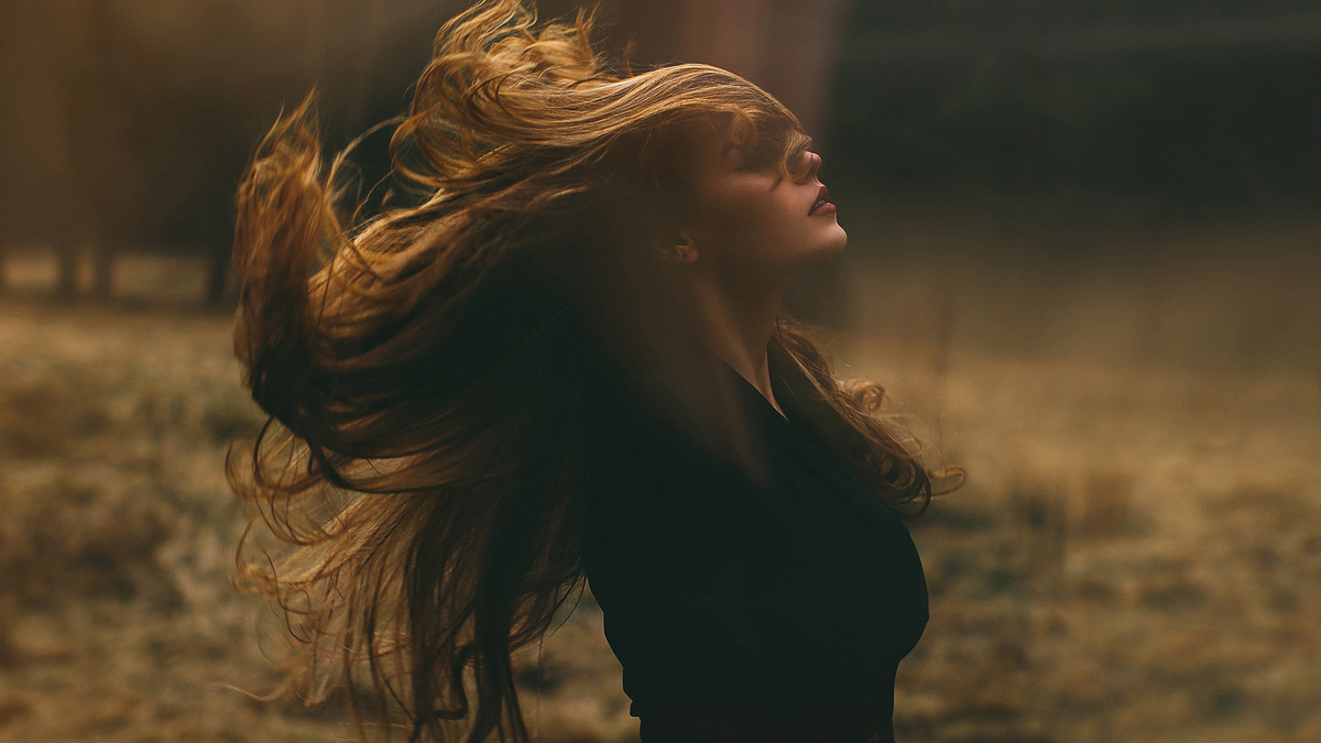 Woman Wind Long Lux Hair Autumn Forest Девушка брюнетка с роскошными длинными волосами стоит в пасмурном лесу ее волосы развеваются по ветру