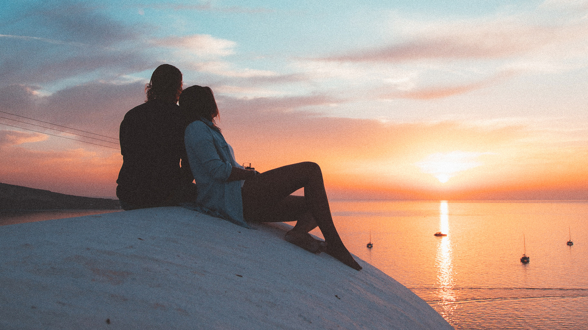 Couple Sunset Ocean View Двое влюбленных сидят и смотрят на малиновый закат солнца в сторону океана моря