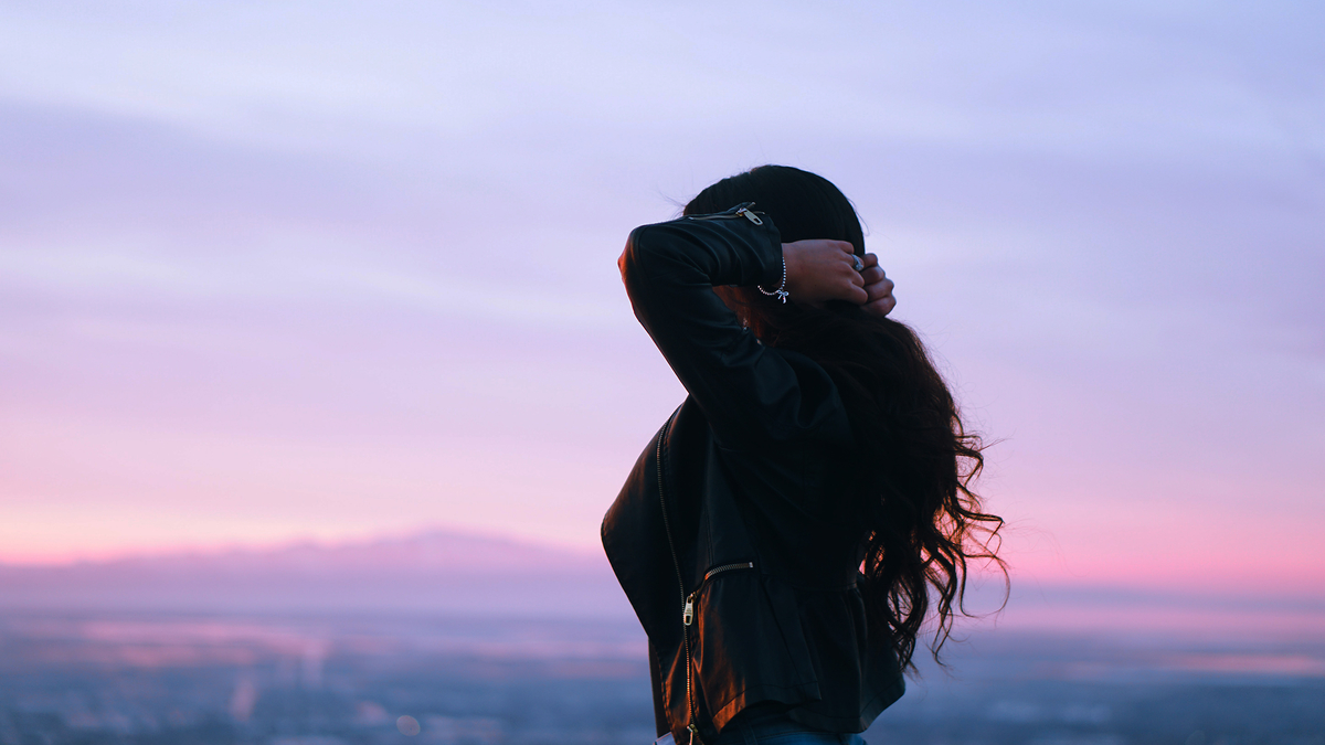 Woman Brunette Sunset Cityscape Девушка брюнетка на фоне города в малиновый закат держит свои волосы руками в кожаной куртке