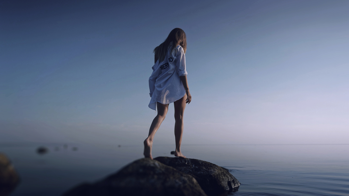 Woman Blonde Sunset Rocks Ocean Sea Девушка блондинка в рубашке стоит на камнях на берегу океана на фоне заката солнца