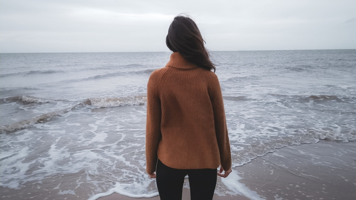 Woman Outdoor Sea Ocean Wind Rain Jacket Девушка брюнетка стоит спиной к камере на фоне шторма океана моря